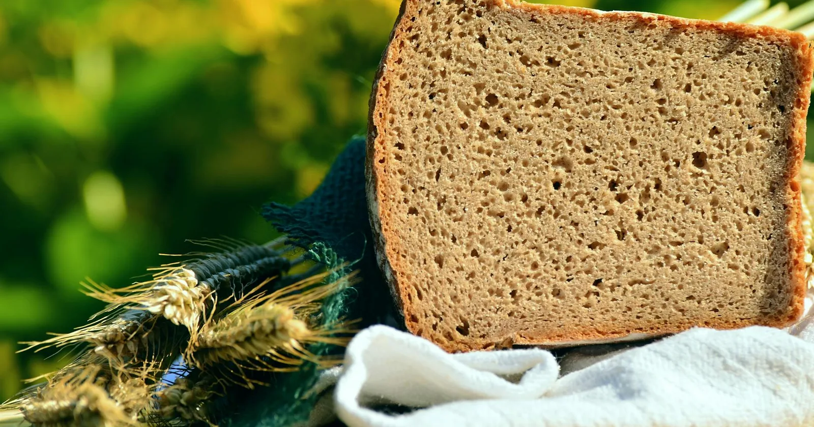 Rustic bread and wheat stalks representing the gluten-containing grains that celiac sufferers must avoid.
