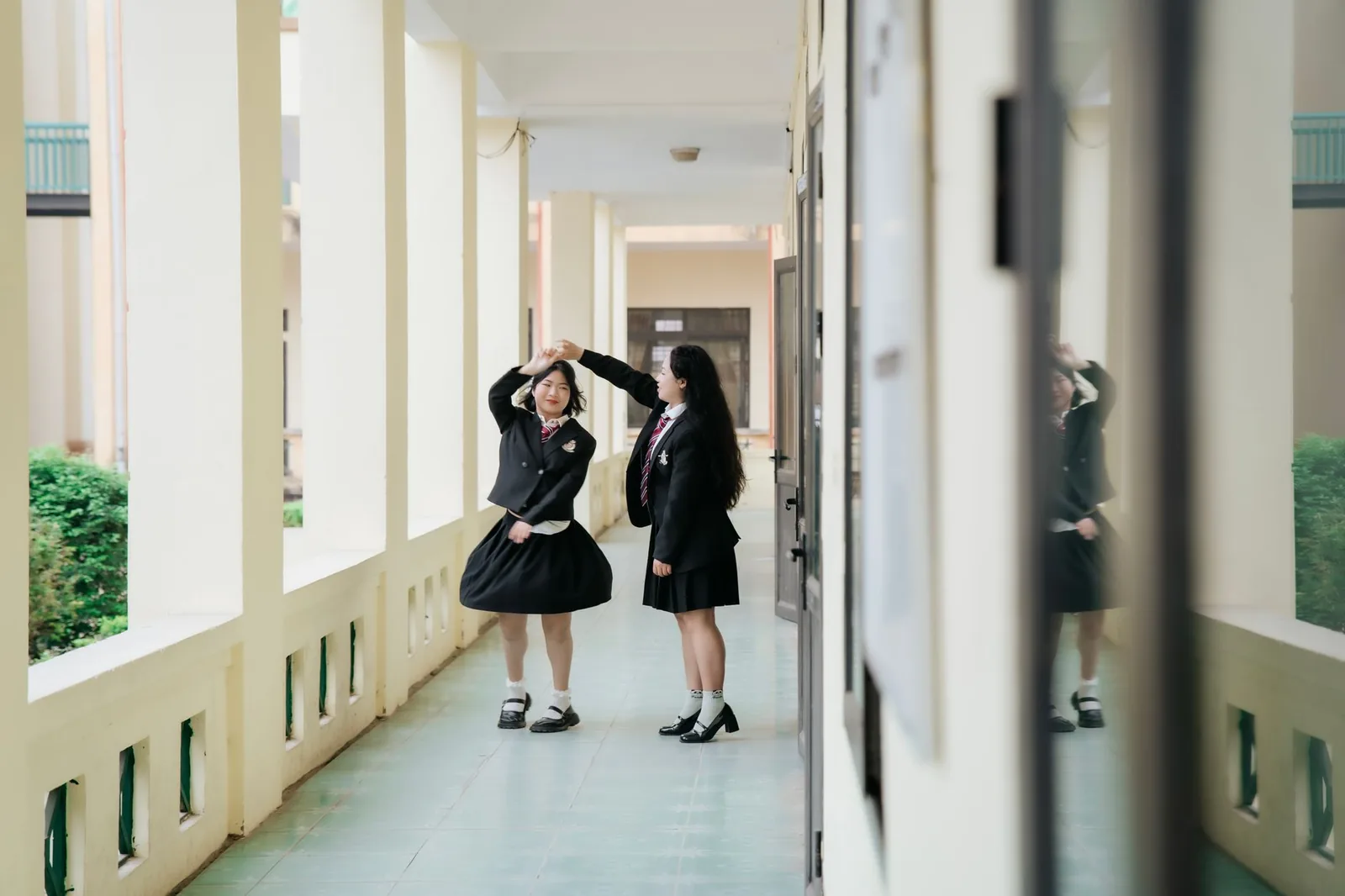 Two teenage students in uniform in a school corridor